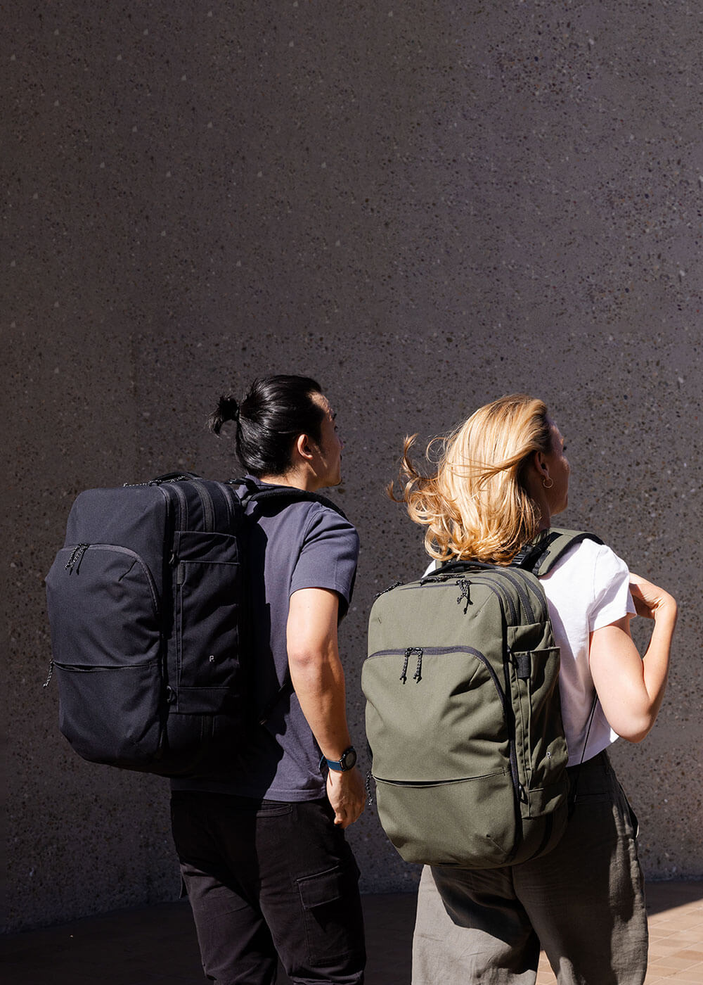 man and woman walking with travel backpack