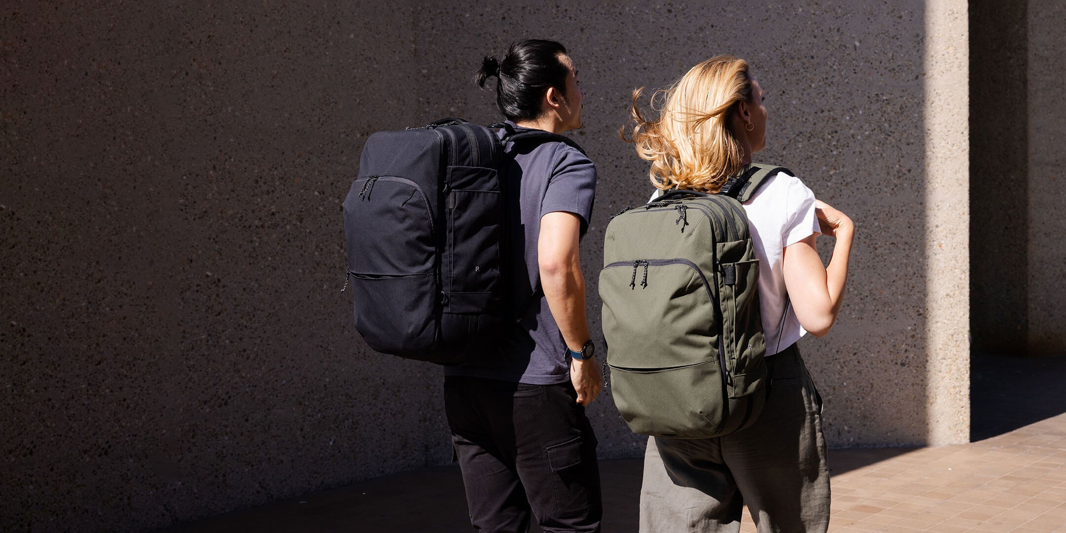 Man and woman walking with travel backpack